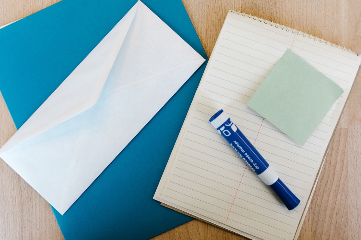 A signed document, a courier envelope and a folder of invoices on a desk
