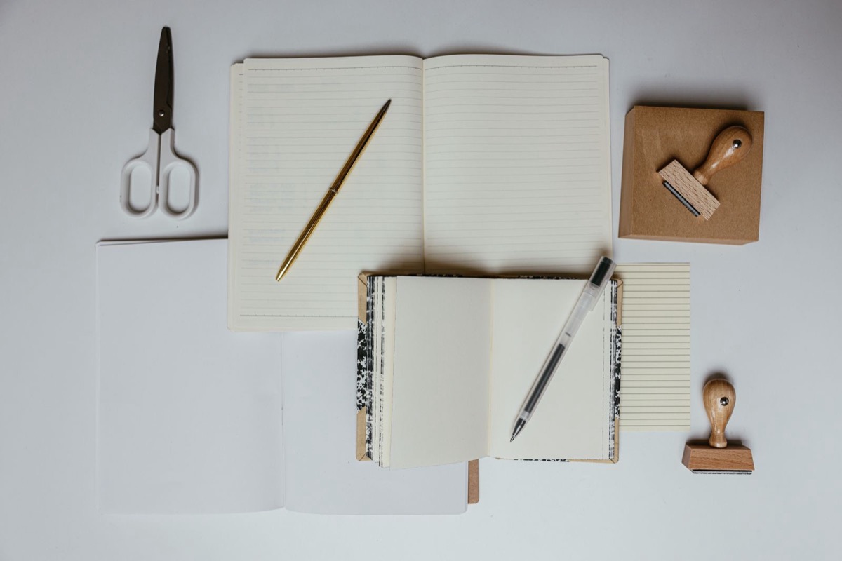 Notebooks, a pen and stationery on a white table