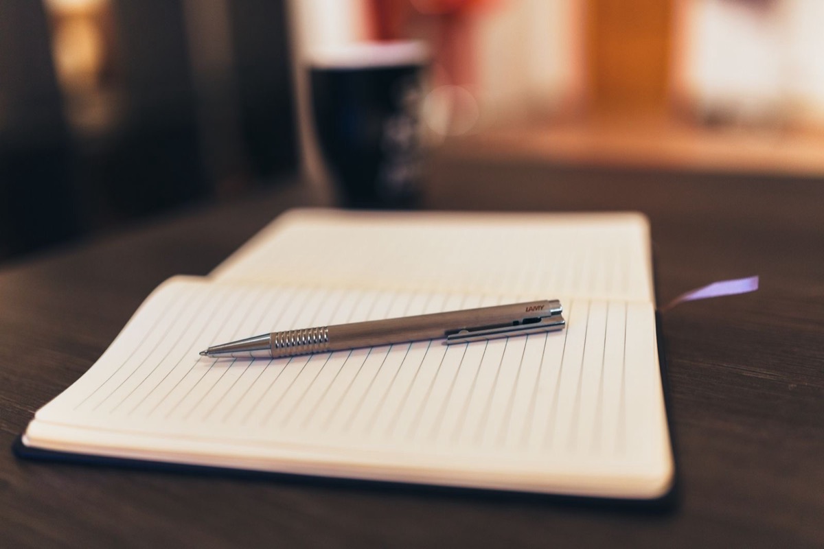 An open notebook and a pen on a table