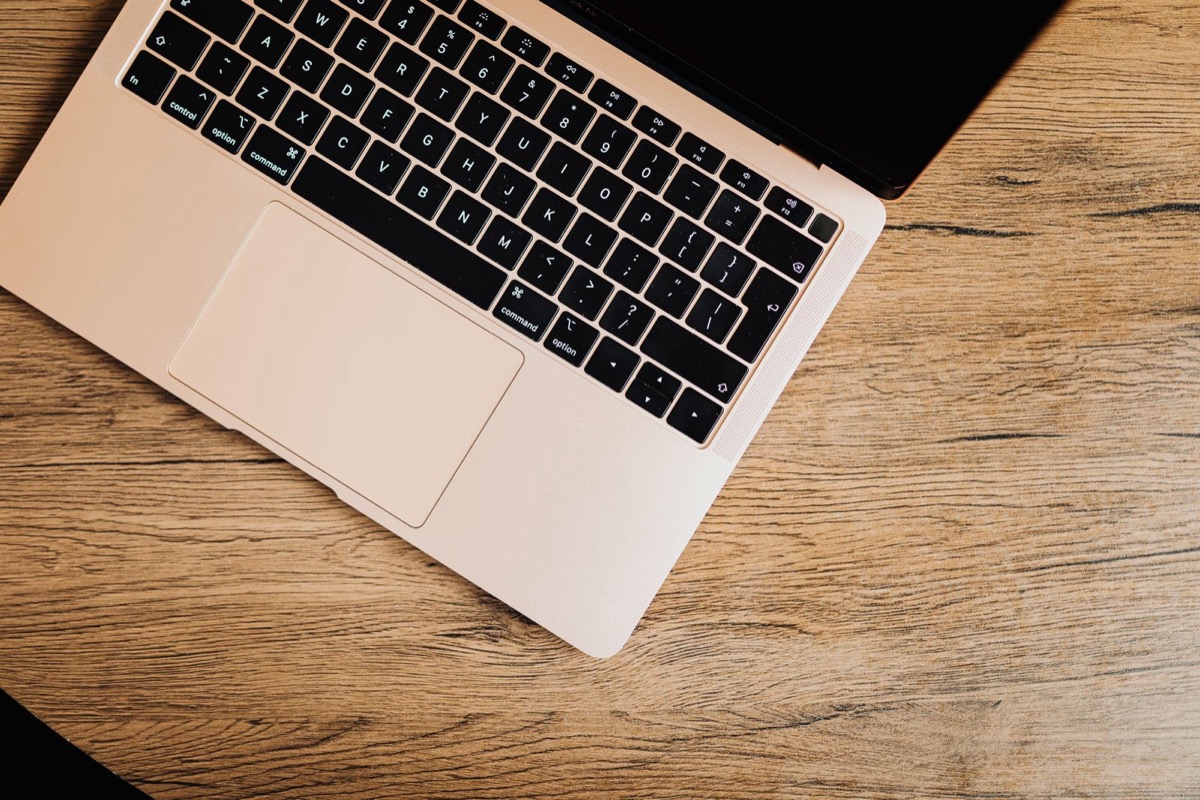 A laptop on a wooden desk, seen from above