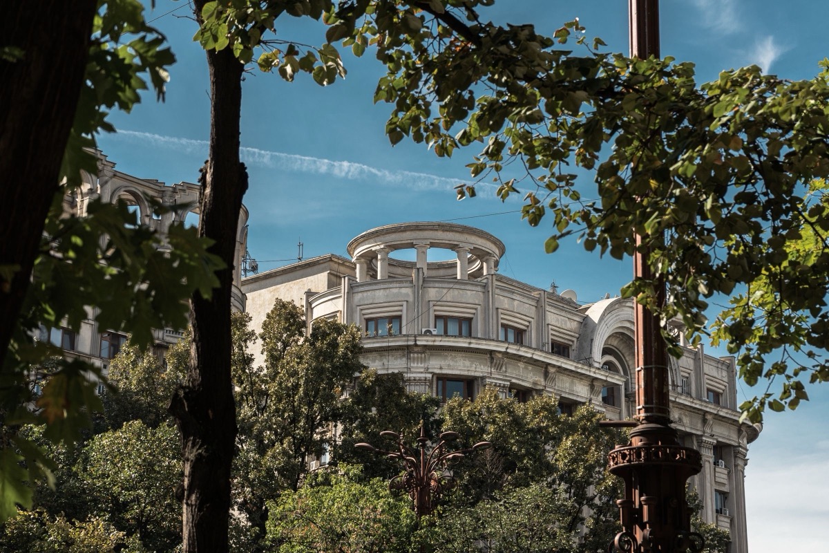 A historic building in Bucharest seen through trees